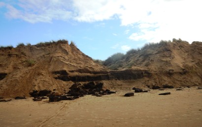 Mounds of dumped tobacco being eroded by the sea (scale: 1m)