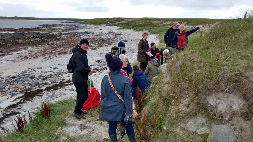 Joanna Hambly of SCAPE and members of UCAG gather round a midden at Traigh Nam Faoghailean, North Uist