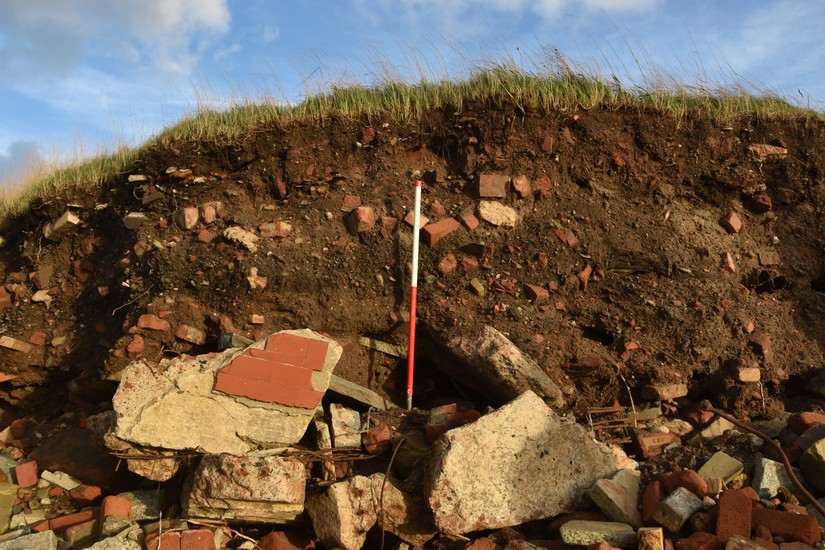 A gravestone is eroded out of the foreshore at Crosby by the sea